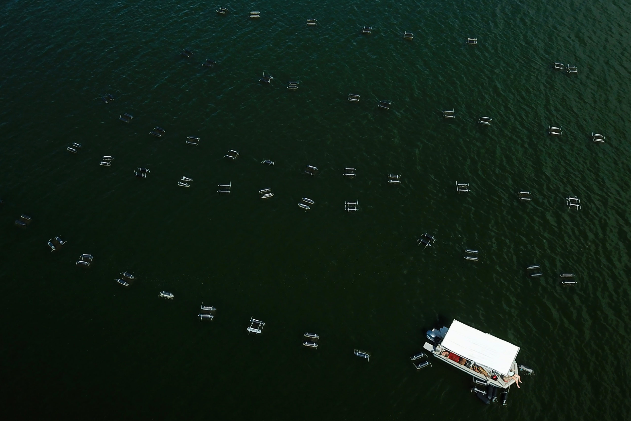 A boat inspects off-bottom oyster cages at Grand Isle Sea Farms
